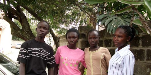 Tres niñas y un niño posan para la fotografía en África.