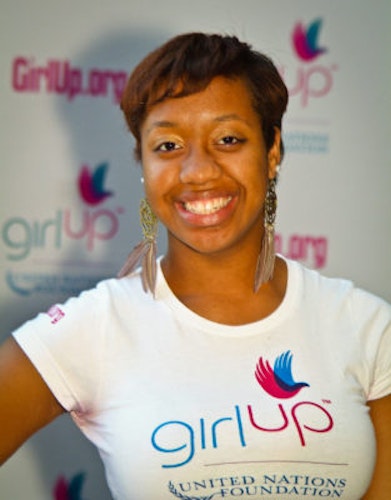 Angelique Gaston Hometown: Washington, D.C._2011-2012 Class The second class of Teen Advisors (close angle headshot) a teen girl wearing her girl up white shirt with her smiley face facing the camera, and background is girlup.org board
