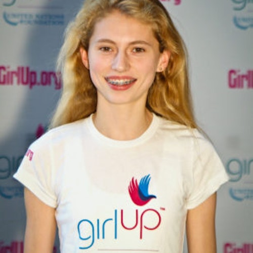 Avery McCall_家乡： 美国伊利诺伊州温内特卡_2011-2012 届（即第二届）青年顾问（近距离头像照），照片中的她穿着白色 Girl Up T 恤，面对镜头微笑，照片背景为 girlup.org 活动展板
