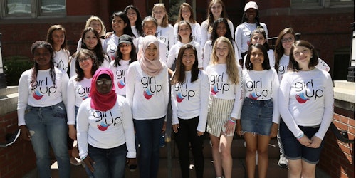 Fotografía grupal de chicas de Girl Up sonriendo y usando las camisetas de Consejeras adolescentes.