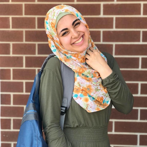 Ganna Omar 2019-2020 Teen Advisors (retrato) com o seu rosto sorridente virado para a câmara e as suas flores amarelas Hijab