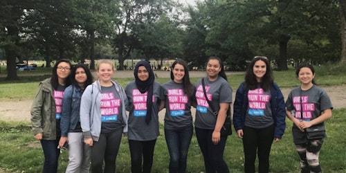 一群不同种族的 Girl Up 女孩在公园里穿着印有“girls run the world”的 T 恤