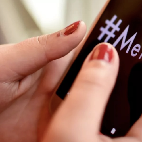 (plan rapproché) main d’une jeune fille tenant un téléphone portable sur lequel on aperçoit #metoo