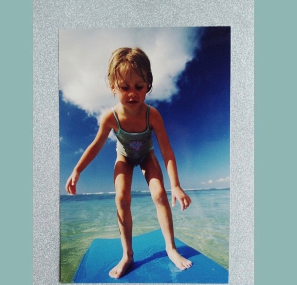 a little girl trying to stand up still on her float board
