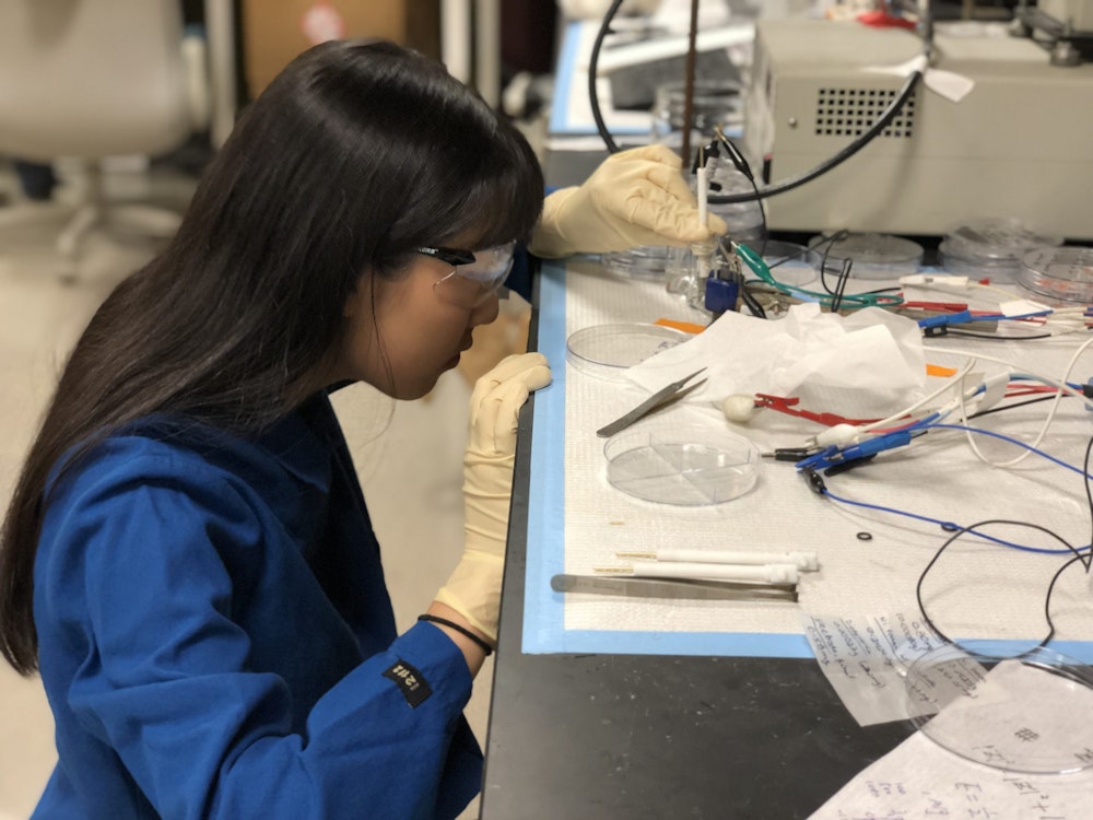 Annie Ma working in a lab with her lab cloth