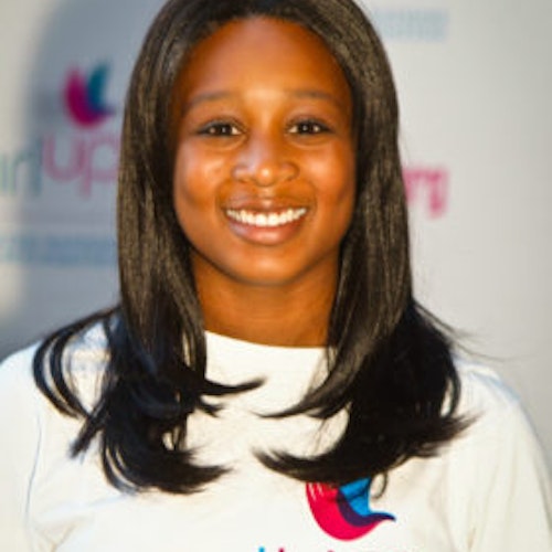 Joi Collete Stevens_Hometown: San Antonio, TX_2011-2012 Class The second class of Teen Advisors (close angle headshot) a teen girl wearing her girl up white shirt with her smiley face facing the camera, and background is girlup.org board