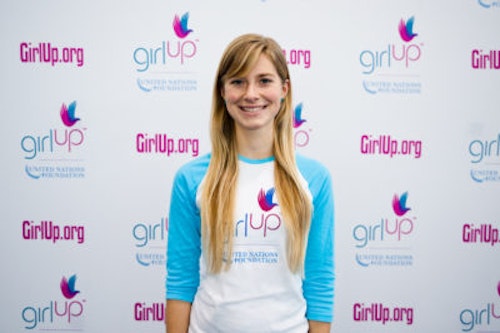 Karina Jougla_ The founding class of Teen Advisors(close angle, but not clear picture headshot ) a teen girl wearing her girl up blue long shirt with her smiley face facing the camera, and background is girlup.org board