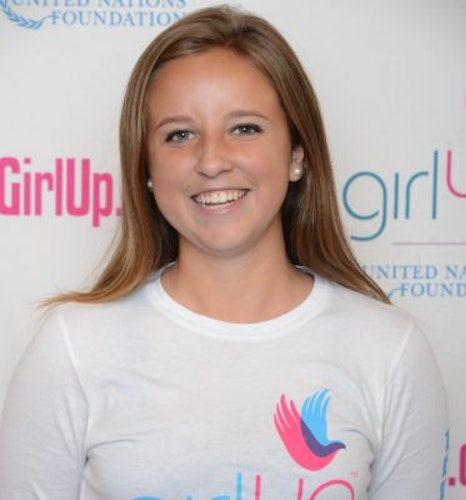 Morgan Wood_ 2014-2015 Teen Advisors (close angle headshot) a teen girl wearing her girl up white shirt with her smiley face facing the camera, and background is girlup.org board