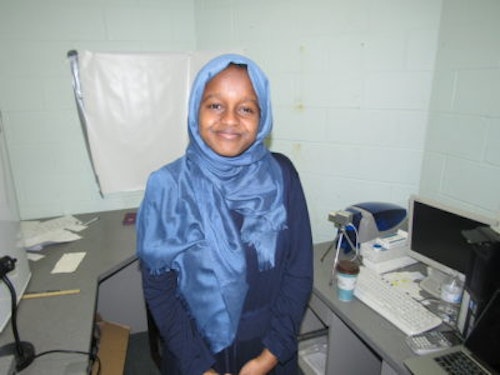 Munira Alimire 2017-2018 Teen Advisors (half body blurry picture) with her blue Hijab and background of a lab