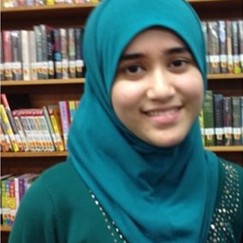 Noorhan Amani, consultora adolescente de 2015-2016 (foto de perto), sorridente olhando para a câmera. Ela está usando um hijab verde