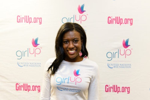 Raven Delk_2013-2014 Teen Advisor (close angle headshot, a picture little blurry ) a teen girl wearing her girl up white shirt with her smiley face facing the camera, and background is girlup.org board
