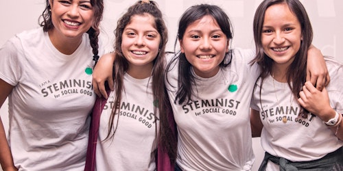 4 teen girls have their arm around each other wearing steminist t-shirt