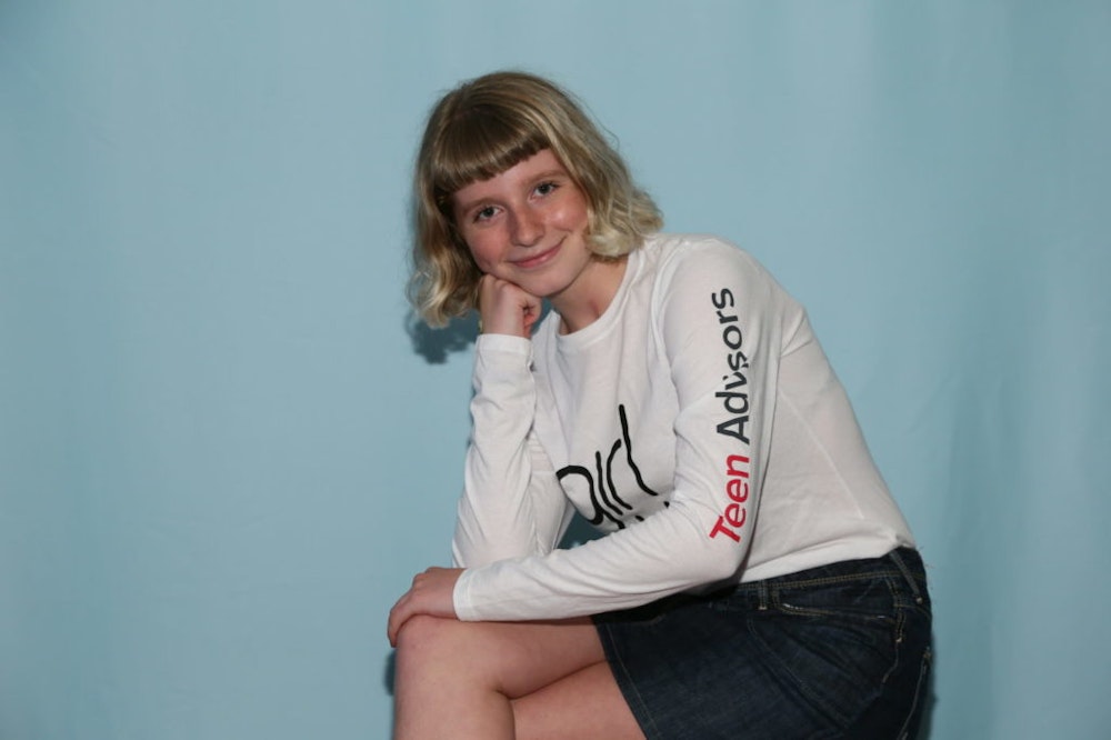 a teen advisor sitting cross her leg and holding her hand up with her right hand