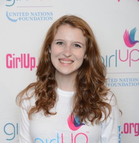 Sarah Gordon_ 2014-2015 Teen Advisors (close angle headshot ) a teen girl wearing her girl up white shirt with her smiley face facing the camera, and background is girlup.org board