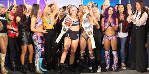 a group of WWE women clapping for the winner on the stage