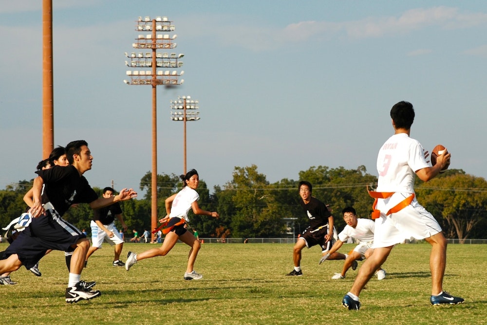 a group of girls playing Flagfootball with boys