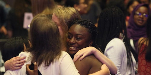 photo de groupe de 4 filles de Girl Up de races différentes se serrant dans les bras