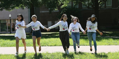 5 teen girls advisers running forward holding each other's hand and smile