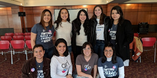 Foto de um evento com nove integrantes da Girl Up usando a camiseta do movimento