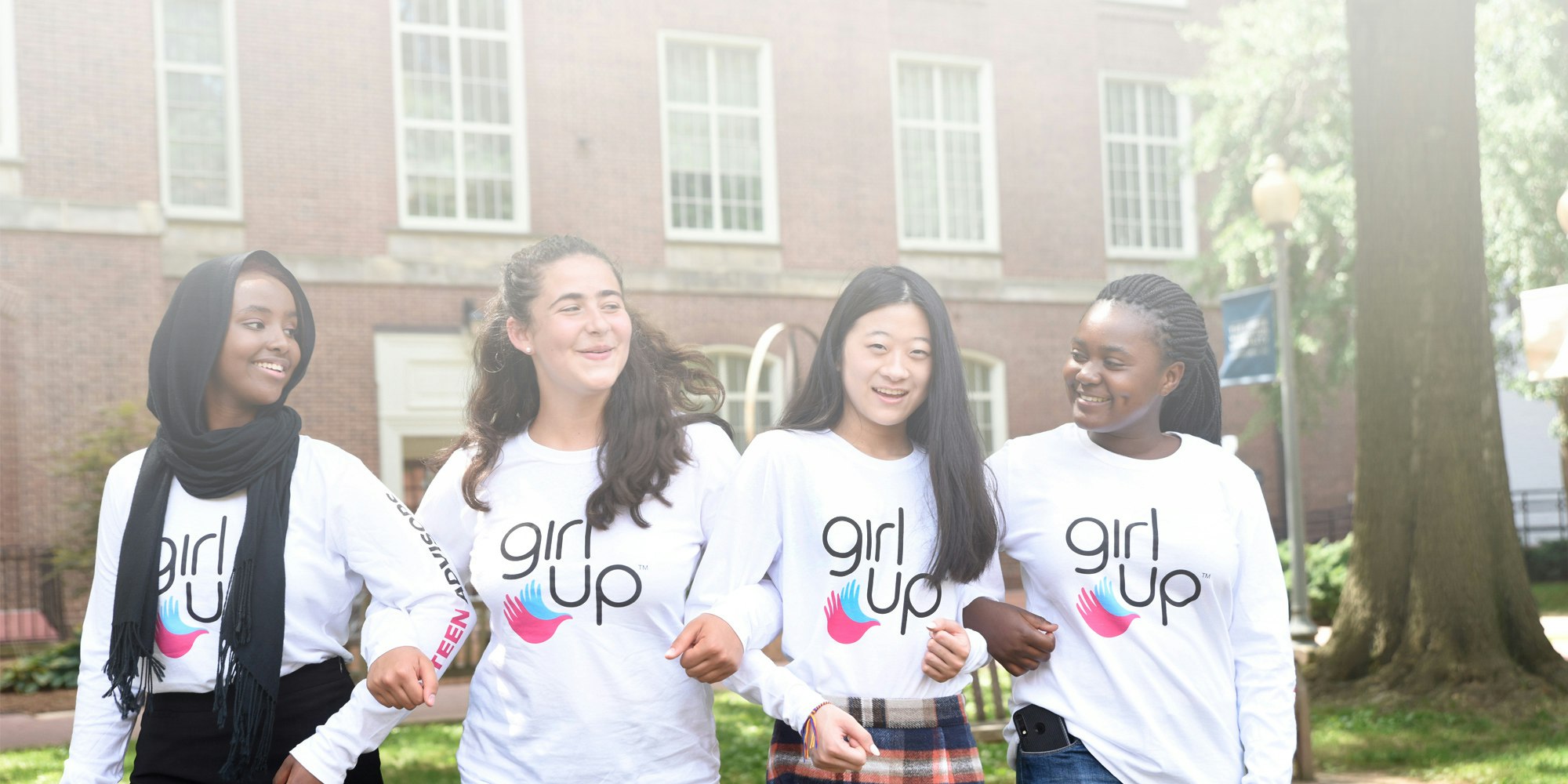 4 chicas étnicas diferentes de Girl Up con la camiseta de Girl Up puesta (foto de grupo)