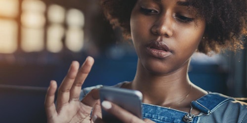 a girl who is looking down and using her finger to scrolling the phone