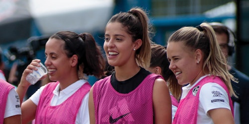 a group of soccer player laughing and looking straight with their uniform