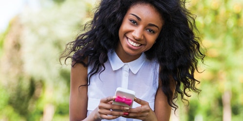 a girl with smile and looking straight and holding her iPhone