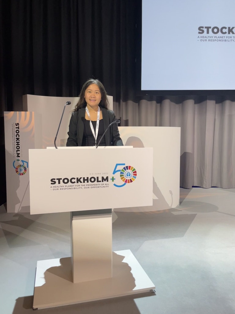 Angela at a podium during a panel at Stockholm +50